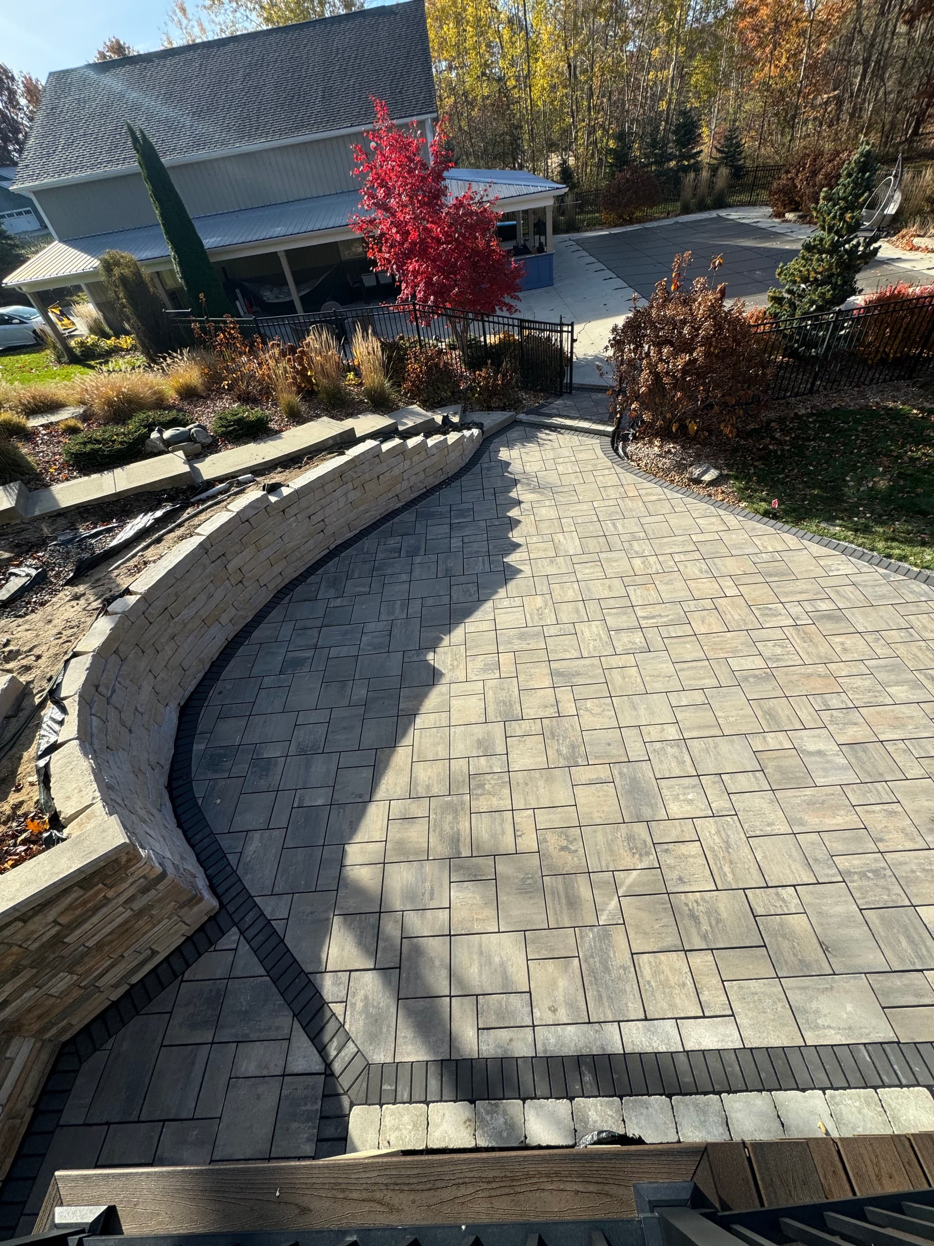 Curved Retaining Wall and Paver Patio Built for Backyard Gatherings