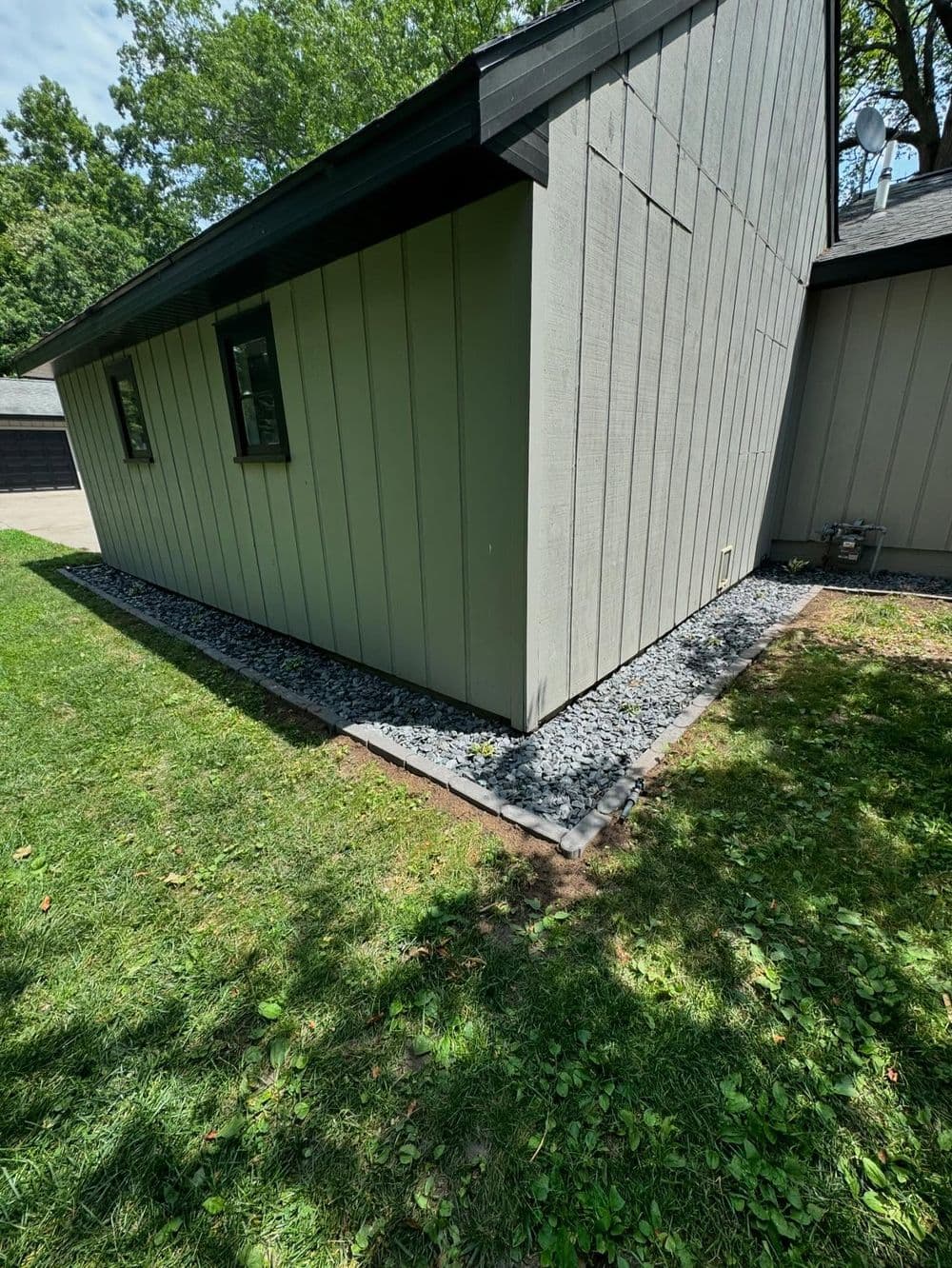 Home exterior featuring a landscaped garden with gravel edging and green grass.